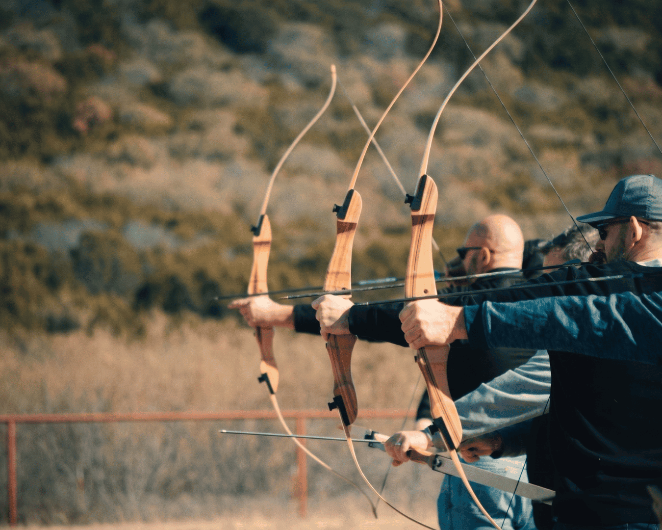 Group of people practicing archery outdoors at Wild Atter Ranch.