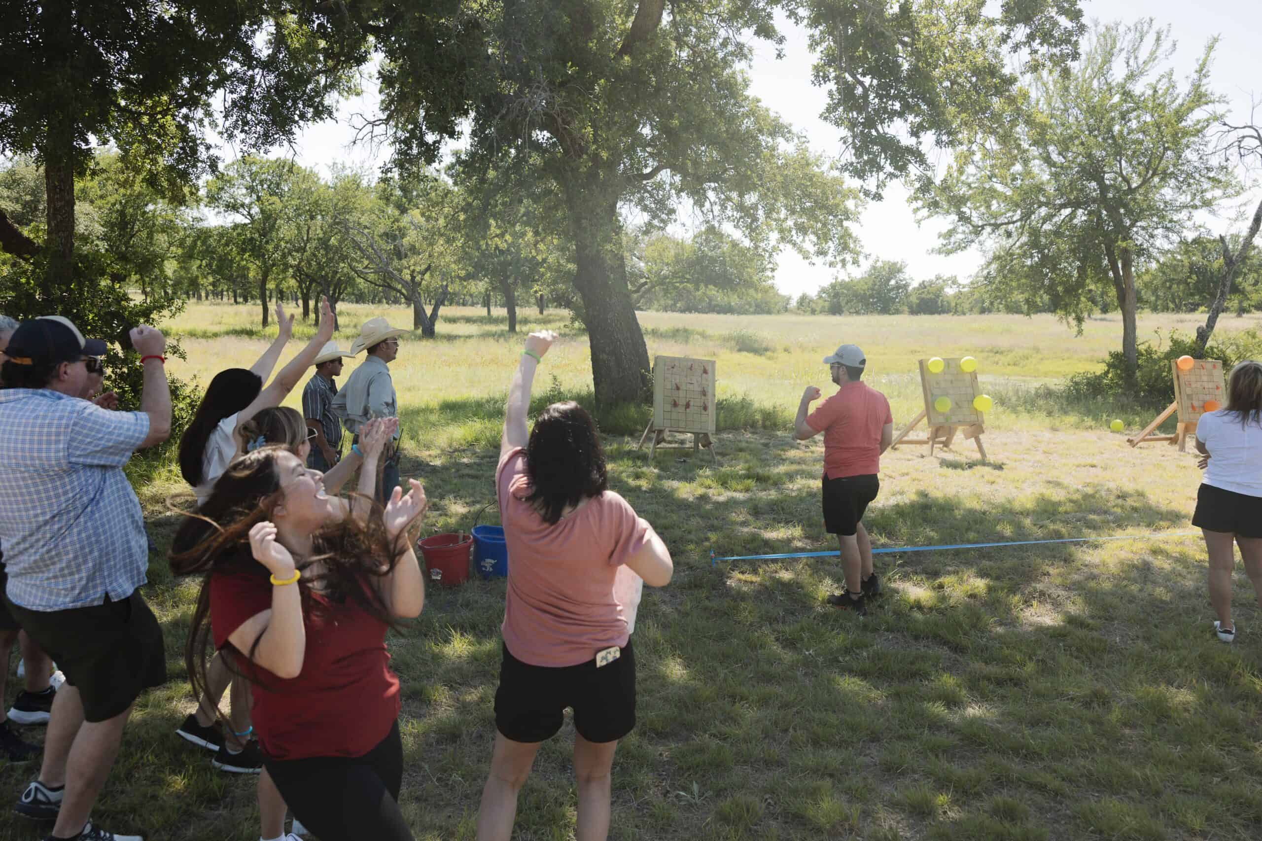 Group of people participating in outdoor archery at Wildcatter Ranch.