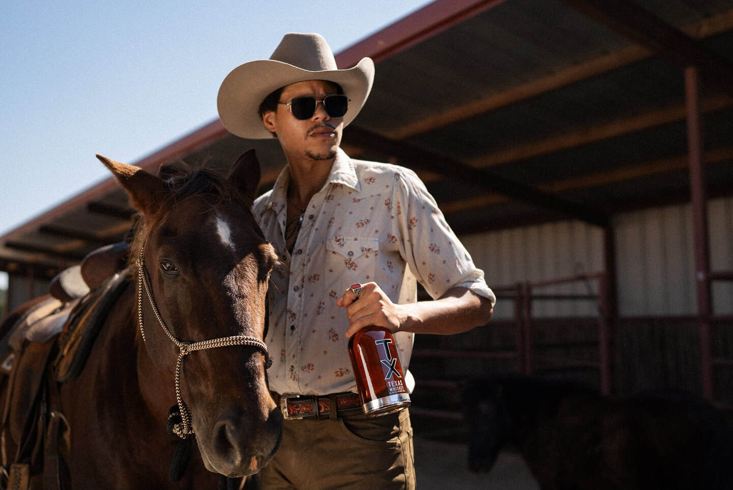 Man in cowboy hat and sunglasses with horse at Wildcatter Ranch.